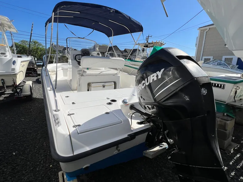 Slide: The Image of 2008 Boston Whaler 210 Dauntless boat with Mercury engine, parked outdoors. - 2