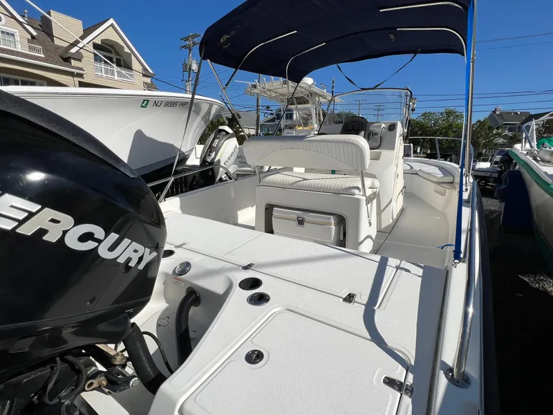 Slide: The Image of 2008 Boston Whaler 210 Dauntless boat with Mercury engine, featuring spacious seating and canopy. - 4