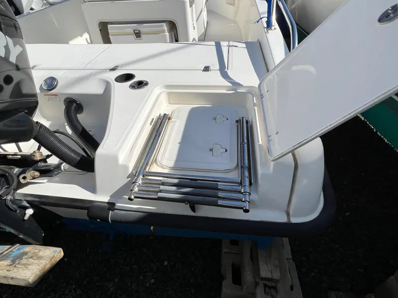 Slide: The Image of 2008 Boston Whaler 210 Dauntless boat with open storage compartment and ladder. - 5