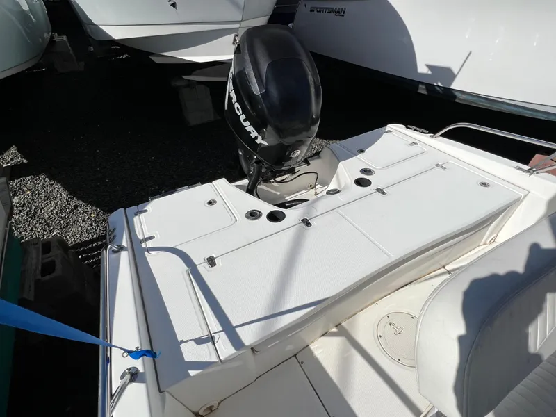 Slide: The Image of 2008 Boston Whaler 210 Dauntless boat with Mercury outboard motor, docked on gravel. - 7