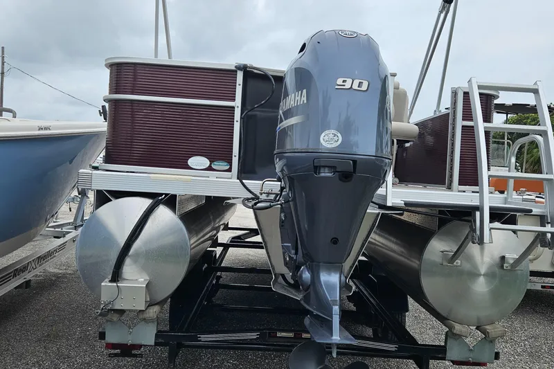 Slide: The Image of 2019 Bennington 20 SX pontoon boat with Yamaha 90 engine, docked on trailer. - 4