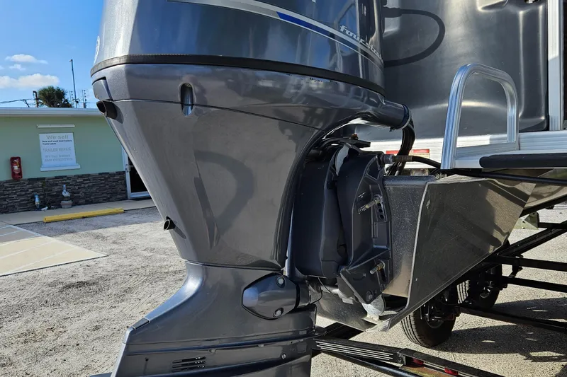 Slide: The Image of 2019 Bennington 20 SX boat motor and stern, parked on a sunny day. - 6