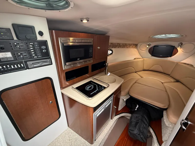 Slide: The Image of 2023 Crownline 270 CR cabin interior with kitchenette, seating area, and modern amenities. - 15