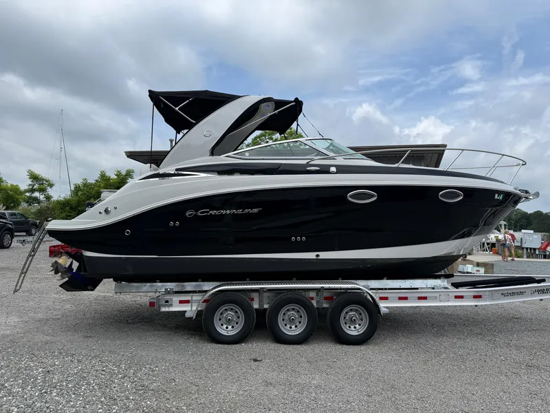 Slide: The Image of 2023 Crownline 270 CR boat on a trailer, black and white design, parked outdoors. - 21