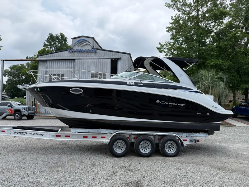Slide: The Image of 2023 Crownline 270 CR boat on trailer, parked outdoors near a building. - 22