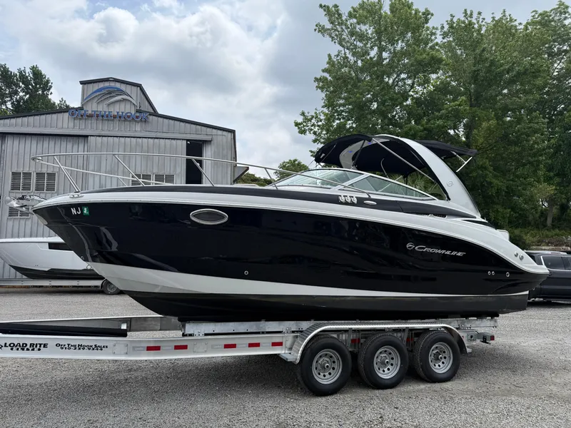 Slide: The Image of 2023 Crownline 270 CR boat on a trailer, parked outdoors near a building. - 3