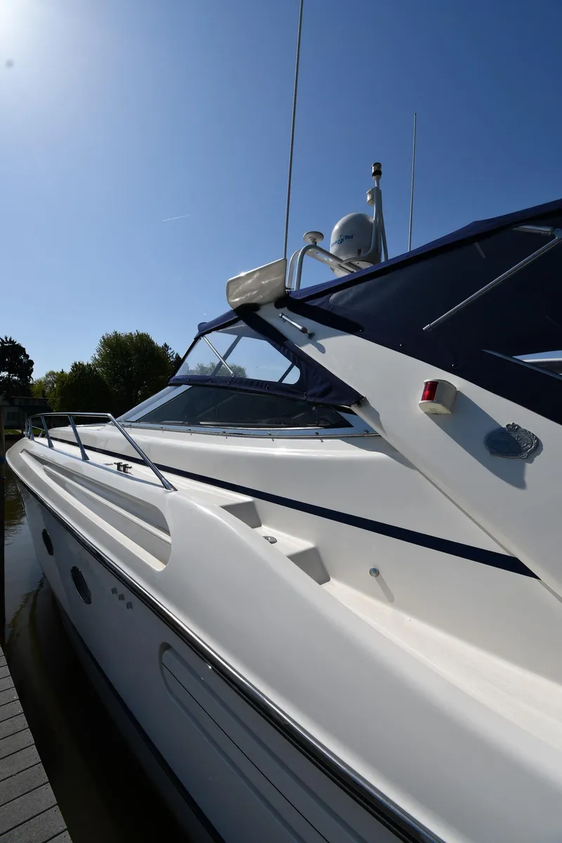 Slide: The Image of 1996 Sunseeker Camargue 51 yacht with sleek design, docked under clear blue sky. - 3
