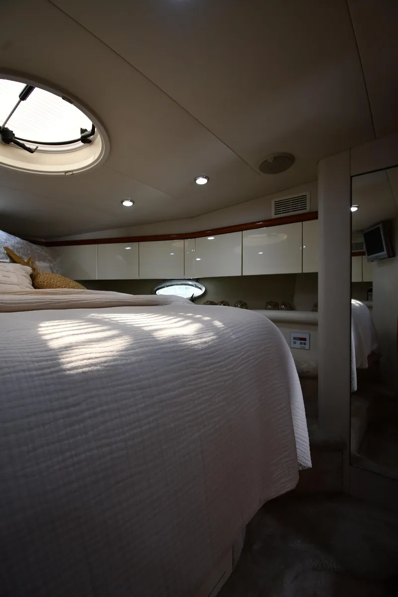 Slide: The Image of Interior cabin of 1996 Sunseeker Camargue 51 yacht, featuring cozy bed and porthole window. - 36