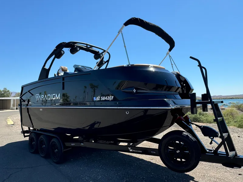 Slide: The Image of 2025 Paradigm 236 Surf SL boat on trailer, sleek black design, sunny day background. - 5