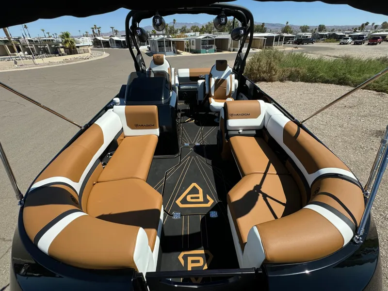Slide: The Image of 2025 Paradigm 236 Surf SL boat interior with tan and white seating, sleek design. - 6
