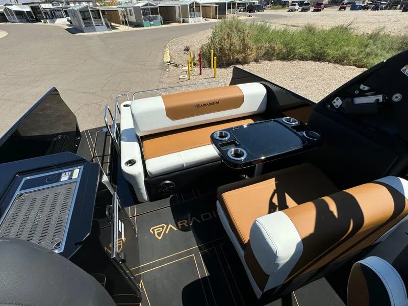 Slide: The Image of 2025 Paradigm 236 Surf SL boat interior with tan and white seating, table, and cup holders. - 8