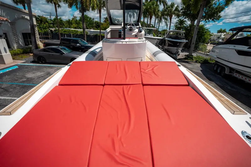 Slide: The Image of 2015 Pirelli 1100 boat with red sunbathing cushions, parked near palm trees. - 20