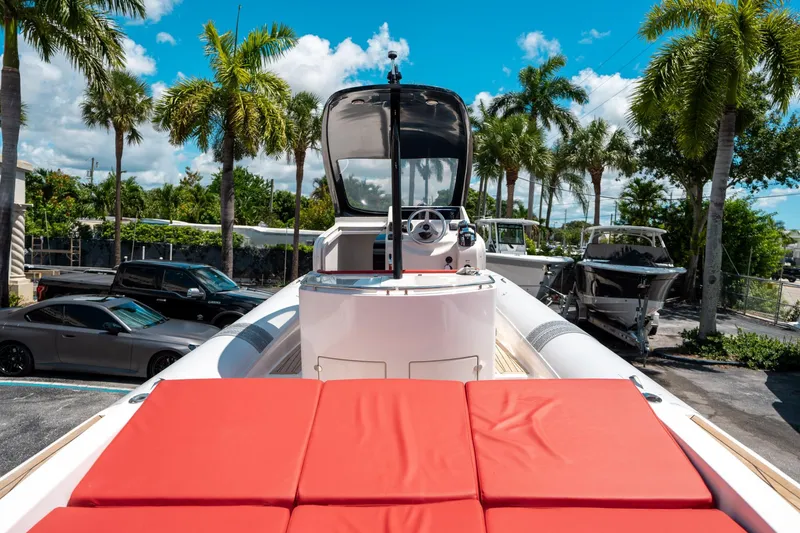 Slide: The Image of 2015 Pirelli 1100 boat with red seating, parked under palm trees. - 21