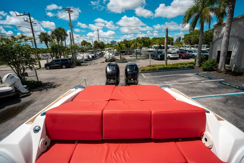Slide: The Image of Pirelli 1100 boat with red seating, parked outdoors, surrounded by palm trees and vehicles. - 22