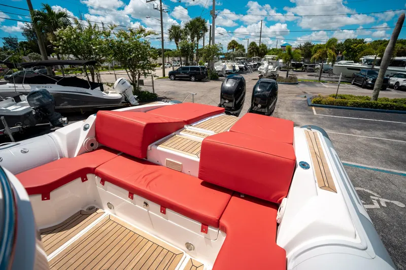 Slide: The Image of 2015 Pirelli 1100 boat with red seating and wooden deck, parked outdoors under blue sky. - 25