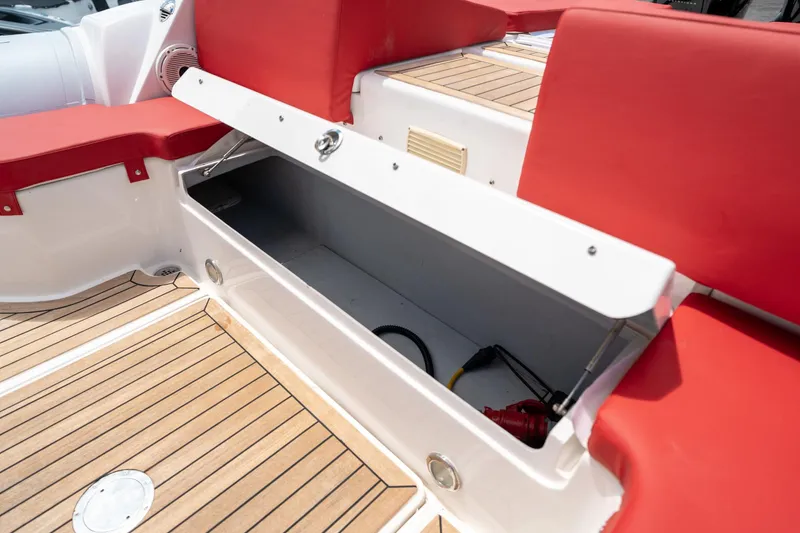Slide: The Image of Open storage compartment on 2015 Pirelli 1100 boat with red seating and wooden deck. - 33