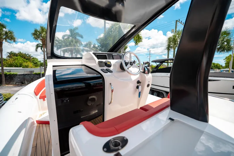 Slide: The Image of 2015 Pirelli 1100 boat interior with steering wheel, red seating, and dashboard under sunny skies. - 46