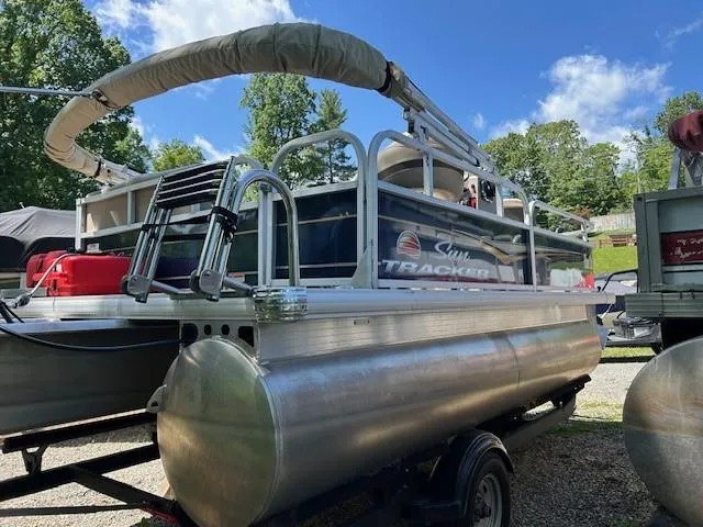 Slide: The Image of 2023 Sun Tracker Bass Buggy 16 XL Select pontoon boat on trailer, outdoors. - 19
