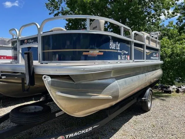 Slide: The Image of 2023 Sun Tracker Bass Buggy 16 XL Select pontoon boat on trailer, parked outdoors. - 24