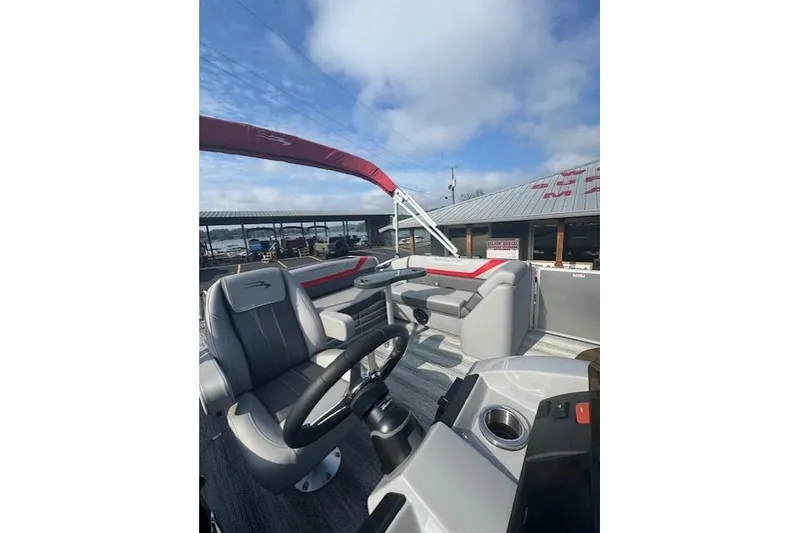 Slide: The Image of 2025 Bennington 22 SSXB boat interior with steering wheel and seating under blue sky. - 10