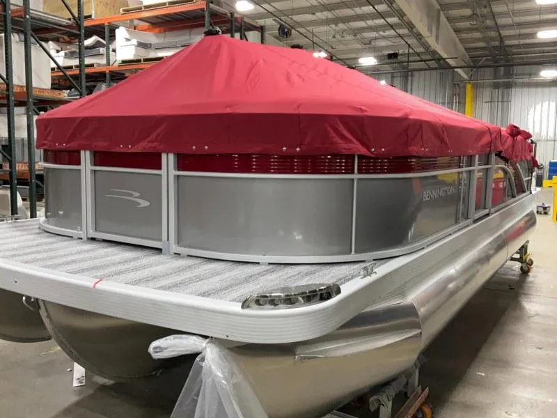 Slide: The Image of 2025 Bennington 22 SSXB pontoon boat with red canopy in a warehouse setting. - 4