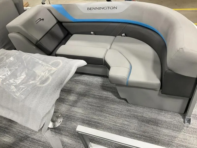 Slide: The Image of 2025 Bennington 22 SSRX boat interior with gray and blue seating on a carpeted floor. - 4