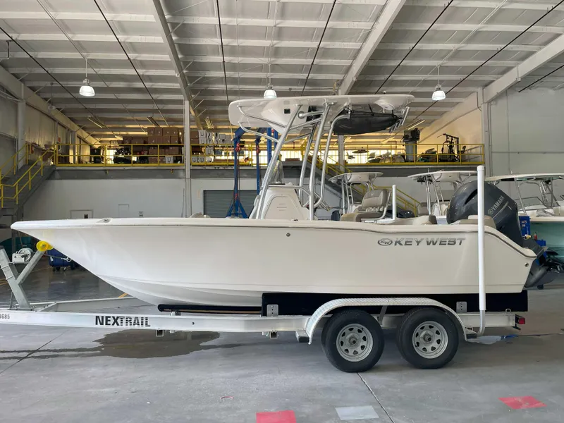 Slide: The Image of 2023 Key West 203 FS boat on trailer in warehouse setting. - 1