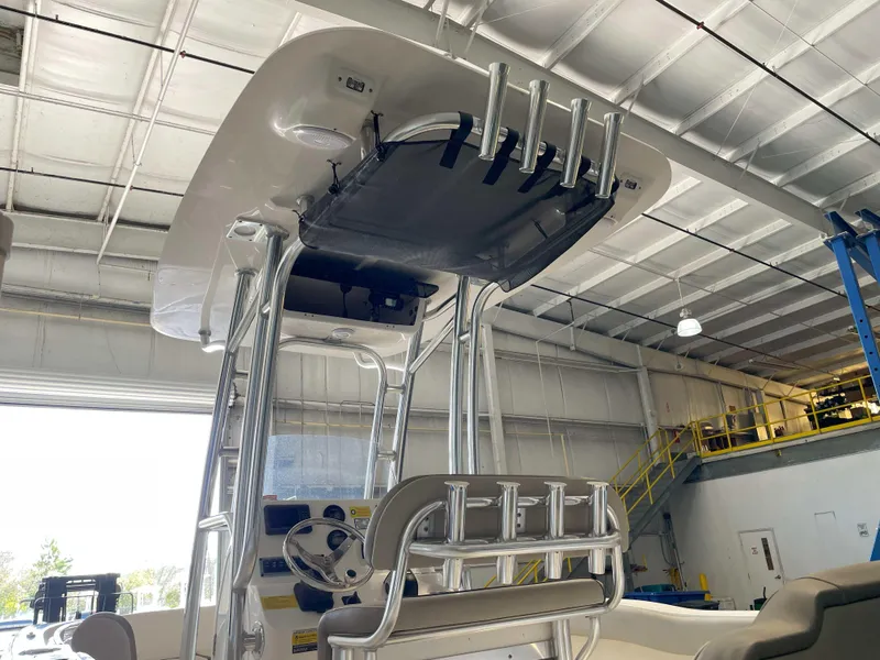 Slide: The Image of 2023 Key West 203 FS boat interior with T-top and rod holders in a warehouse. - 3