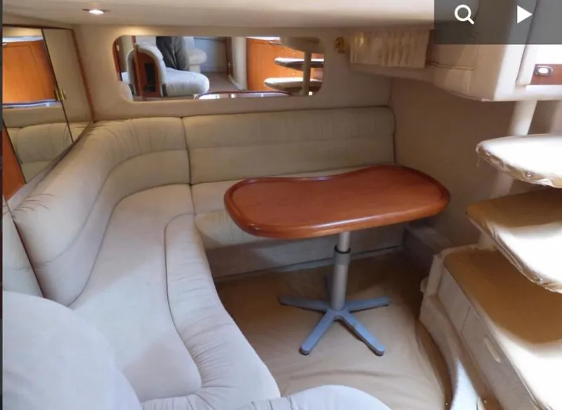 Slide: The Image of 1999 Sea Ray 380 Sundancer interior with beige seating and wooden table. - 10