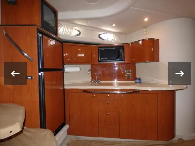 Slide: The Image of 1999 Sea Ray 380 Sundancer interior kitchen with wood cabinetry and modern appliances. - 15