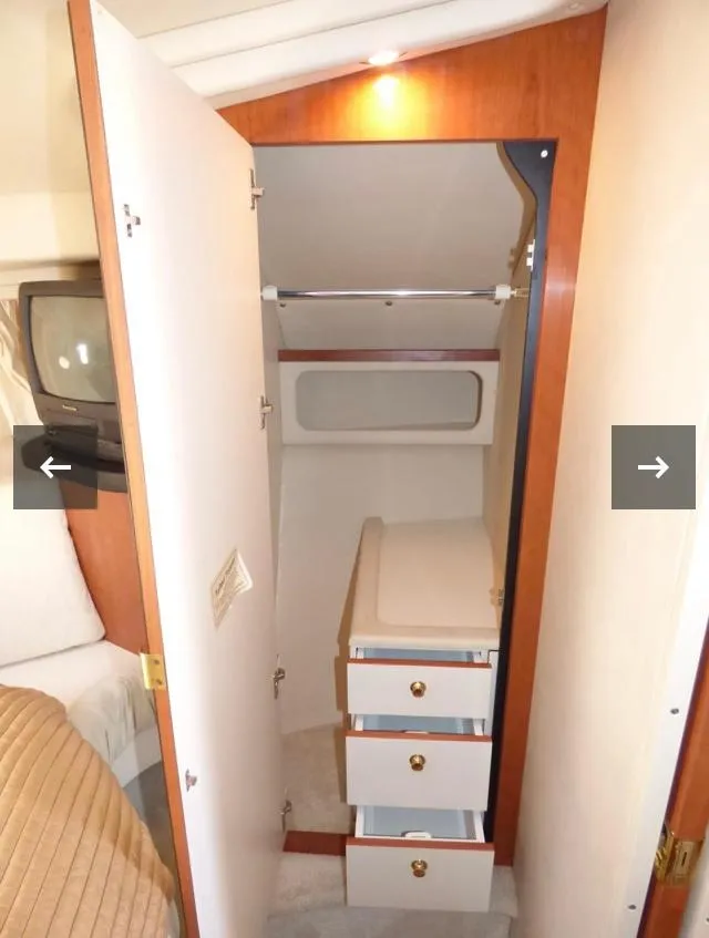 Slide: The Image of 1999 Sea Ray 380 Sundancer cabin closet with drawers and storage space. - 23