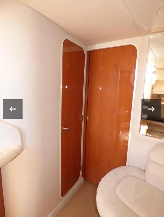 Slide: The Image of Interior of 1999 Sea Ray 380 Sundancer yacht with wooden doors and white seating. - 24