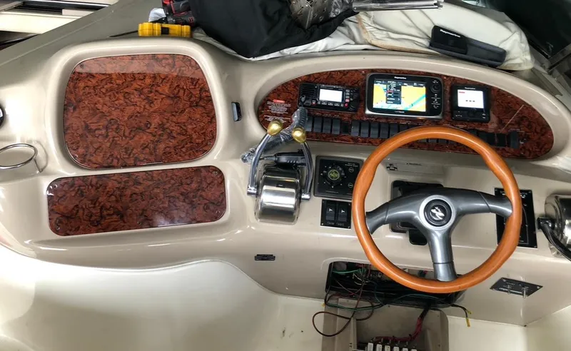 Slide: The Image of 1999 Sea Ray 380 Sundancer helm with wood accents and modern navigation equipment. - 7