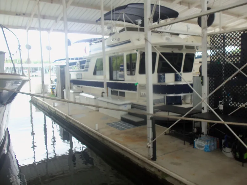 Slide: The Image of 2003 Gibson Classic houseboat docked in a covered marina slip. - 1