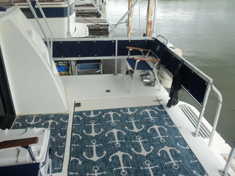 Slide: The Image of 2003 Gibson Classic boat deck with anchor-patterned rug and seating by the water. - 14