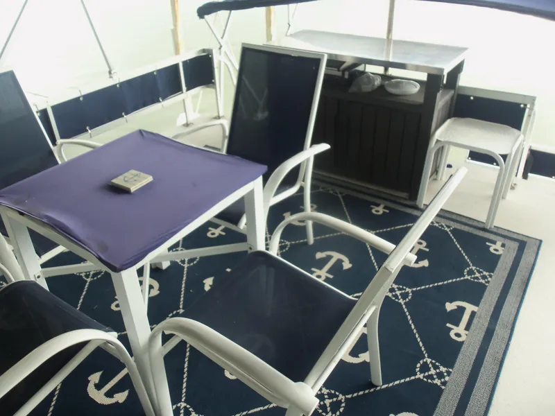 Slide: The Image of Nautical-themed patio with blue chairs and anchor-patterned rug on a Gibson Classic 2003. - 16