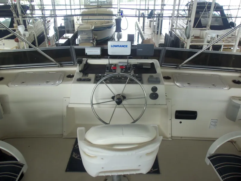 Slide: The Image of Control panel of a 2003 Gibson Classic boat with steering wheel and navigation equipment. - 22