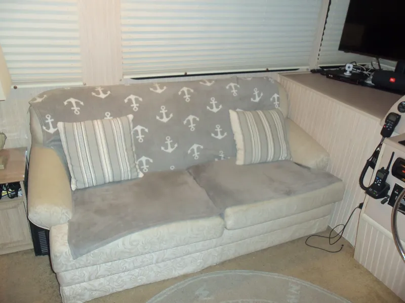 Slide: The Image of Cozy sofa with anchor-themed blanket and striped pillows in a nautical-themed room. - 29