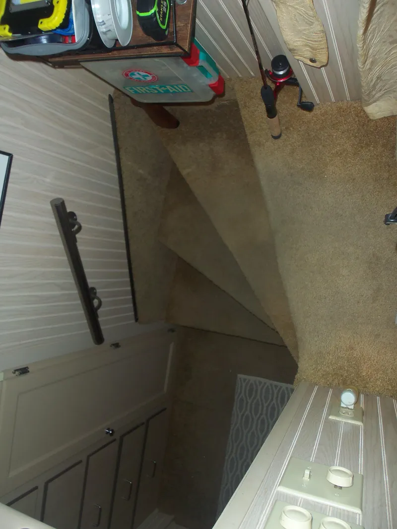 Slide: The Image of Narrow carpeted staircase with wooden paneling and household items. - 43