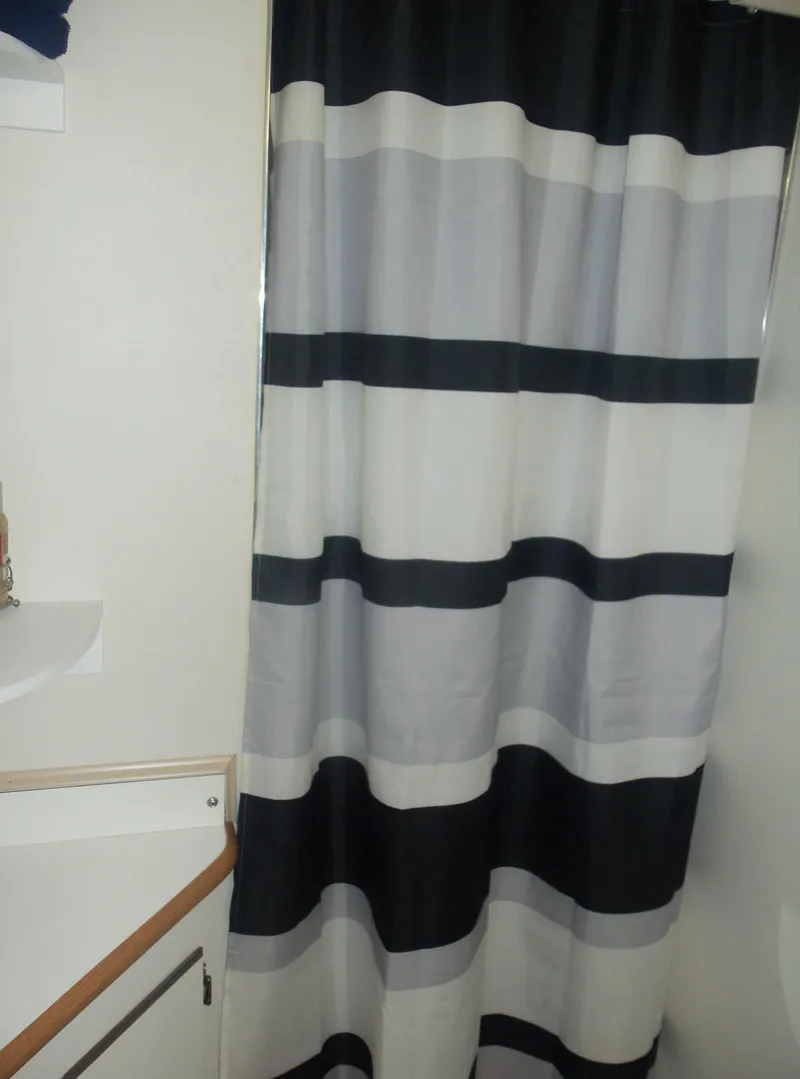 Slide: The Image of Striped shower curtain in a bathroom with white walls and a sink. - 49