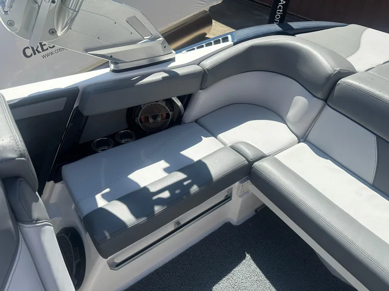 Slide: The Image of 2020 MasterCraft XT20 boat interior with gray and white seating, cup holders, and speaker. - 12