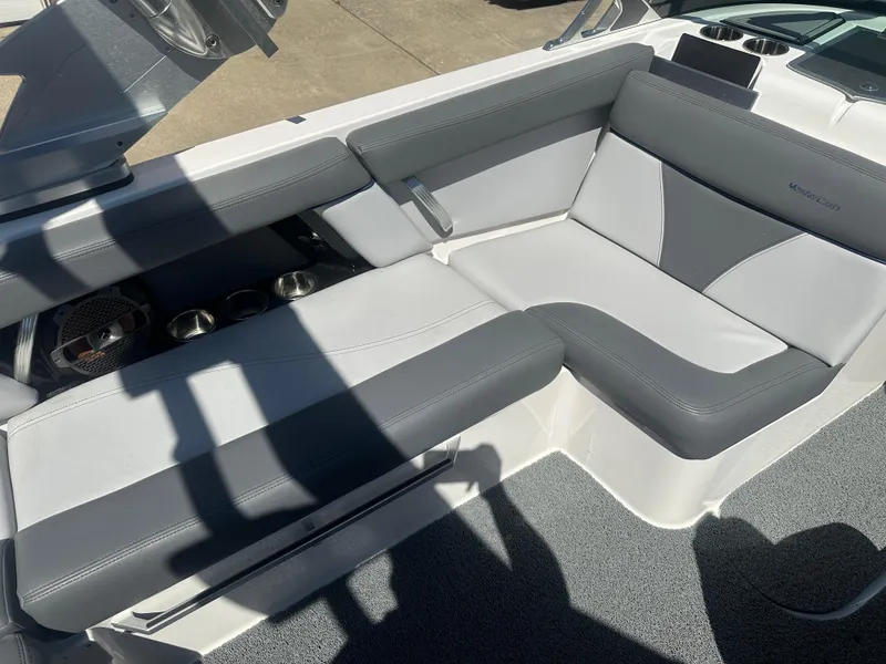 Slide: The Image of 2020 MasterCraft XT20 boat interior with gray and white seating, cup holders, and modern design. - 14
