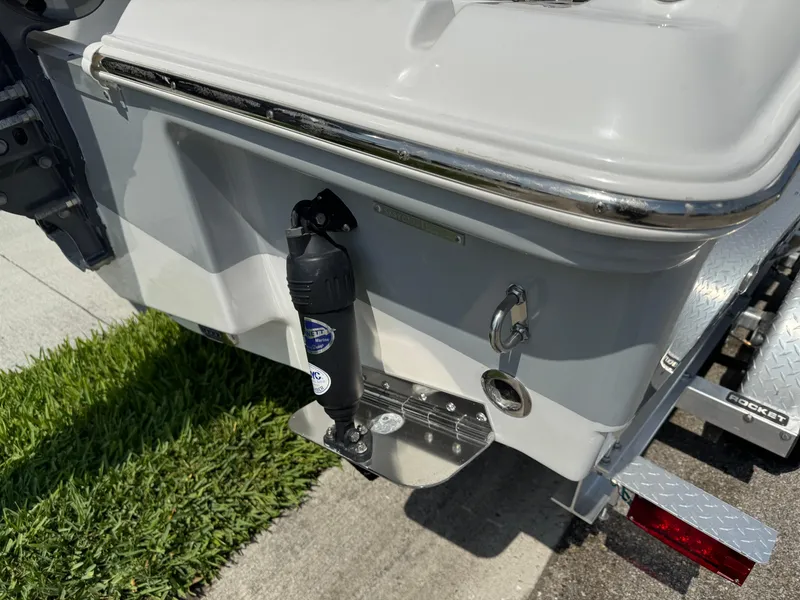 Slide: The Image of 2022 Sea Hunt Ultra 234 boat rear view with trailer and grass background. - 10