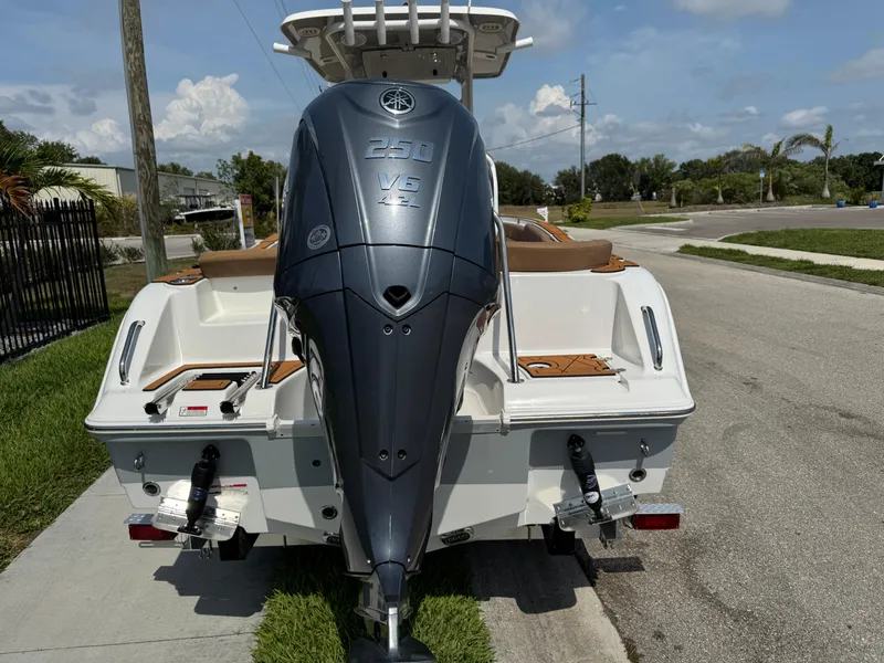 Slide: The Image of 2022 Sea Hunt Ultra 234 boat with Yamaha outboard motor, parked on a sunny street. - 14
