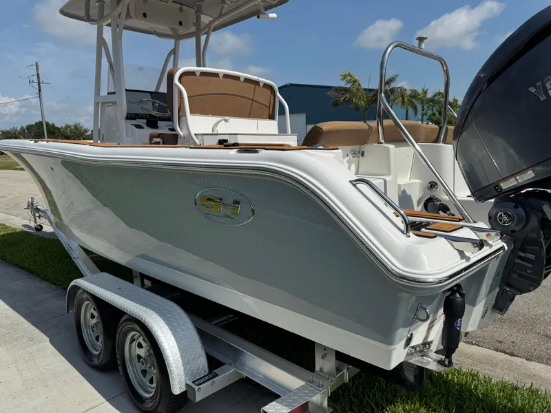 Slide: The Image of 2022 Sea Hunt Ultra 234 boat on trailer, sleek design, parked outdoors. - 19