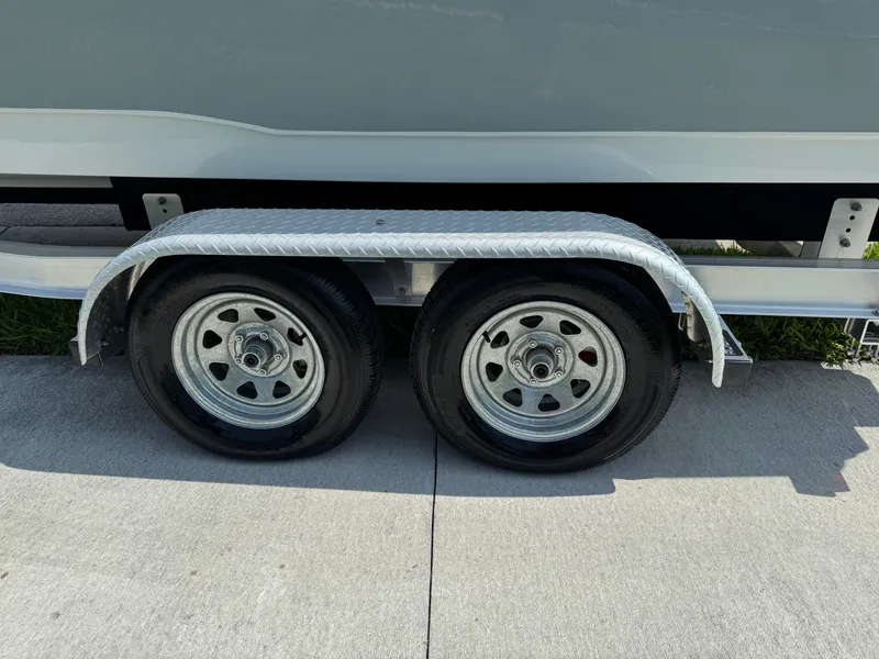 Slide: The Image of Trailer wheels of 2022 Sea Hunt Ultra 234 boat on pavement. - 20