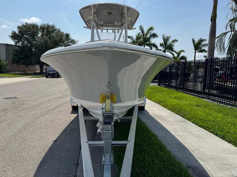 Slide: The Image of 2022 Sea Hunt Ultra 234 boat on trailer, parked on a sunny street. - 25