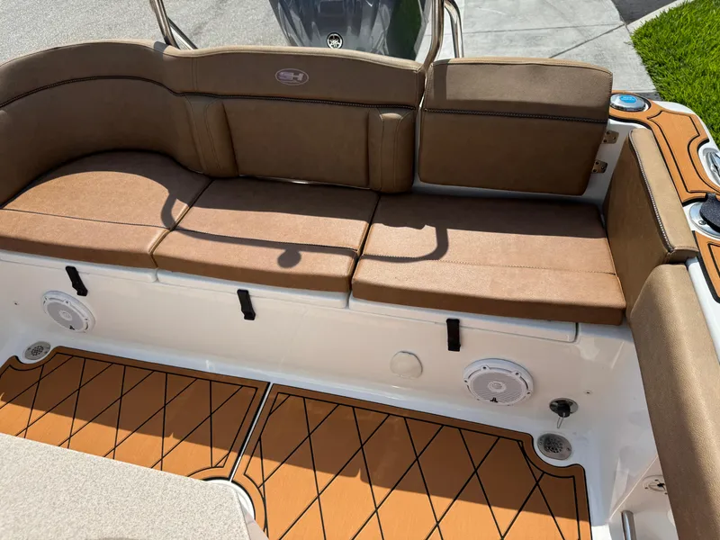 Slide: The Image of 2022 Sea Hunt Ultra 234 boat interior with brown cushioned seating and stylish flooring. - 32