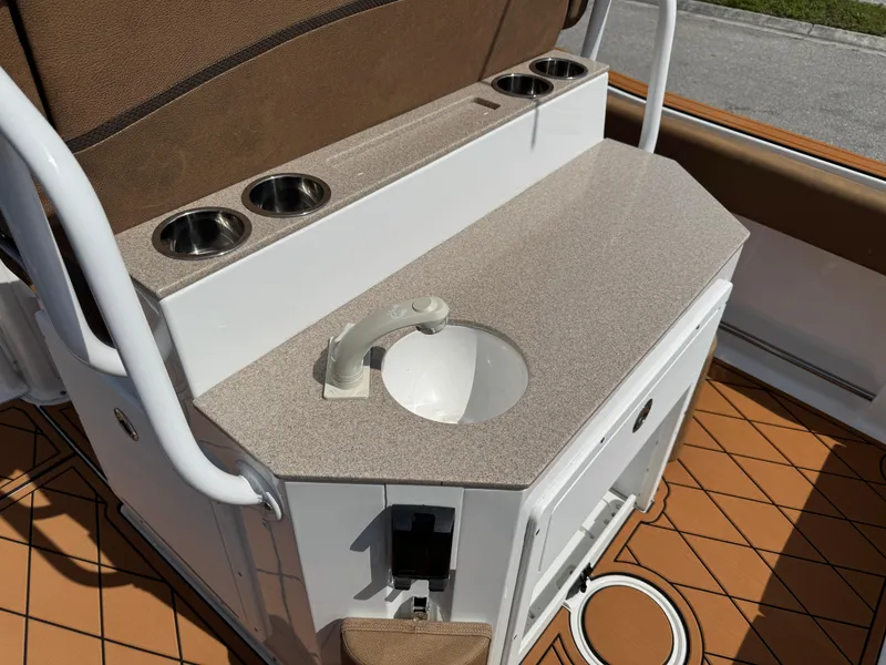 Slide: The Image of 2022 Sea Hunt Ultra 234 boat interior with sink and cup holders. - 33
