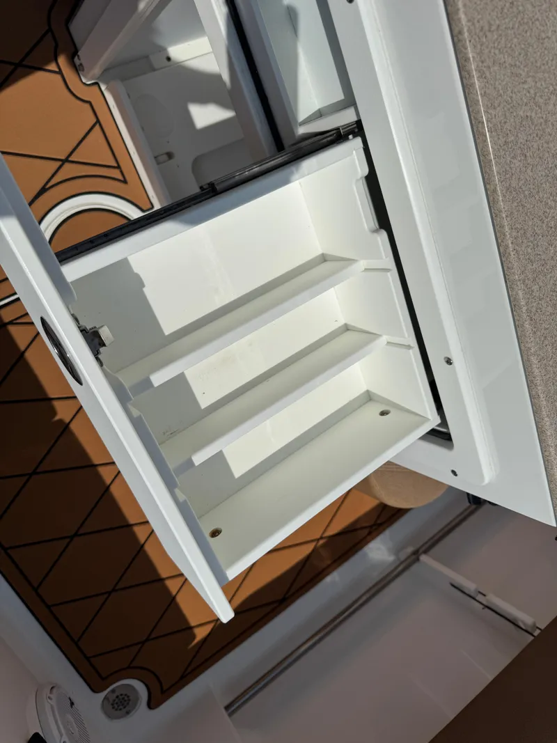 Slide: The Image of 2022 Sea Hunt Ultra 234 boat storage compartment with open shelves. - 36